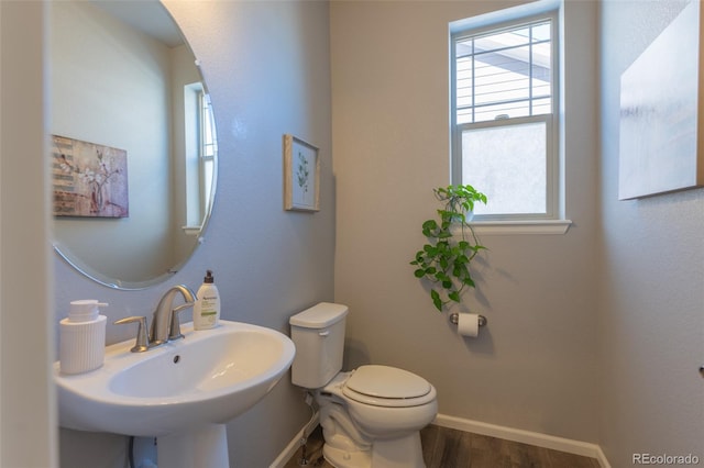 bathroom with toilet, sink, and hardwood / wood-style floors