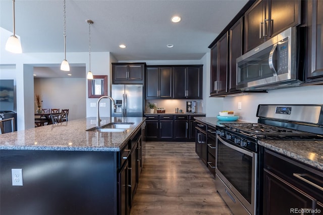 kitchen featuring pendant lighting, stainless steel appliances, and an island with sink