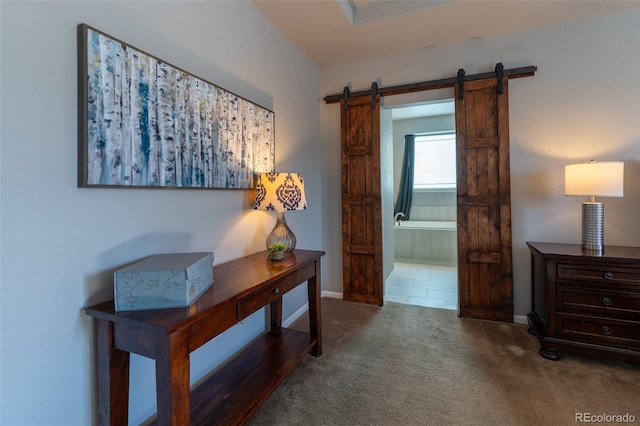 hall featuring a barn door and carpet