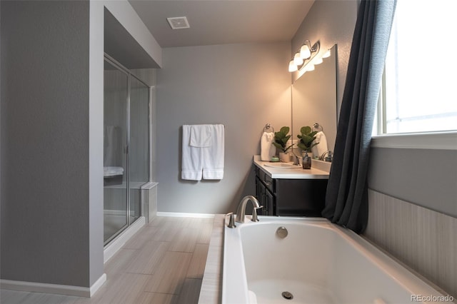 bathroom featuring vanity, hardwood / wood-style floors, and plus walk in shower