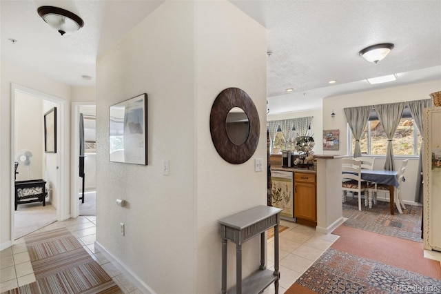 3755 Hartsock Ln Unit 102, Colorado Springs, CO 80917 - corridor featuring light tile patterned floors, a textured ceiling, baseboards, and light carpet