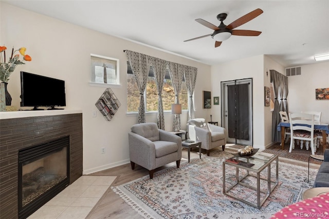 3755 Hartsock Ln Unit 102, Colorado Springs, CO 80917 - living area with a ceiling fan, wood finished floors, a fireplace with flush hearth, and baseboards