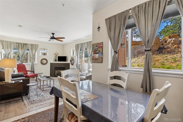 3755 Hartsock Ln Unit 102, Colorado Springs, CO 80917 - dining room with healthy amount of natural light, ceiling fan, a brick fireplace, and wood finished floors