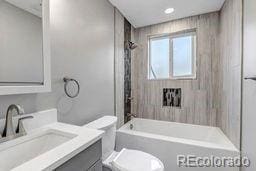 full bathroom featuring tub / shower combination, toilet, and vanity