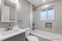 bathroom with shower / washtub combination, toilet, and vanity