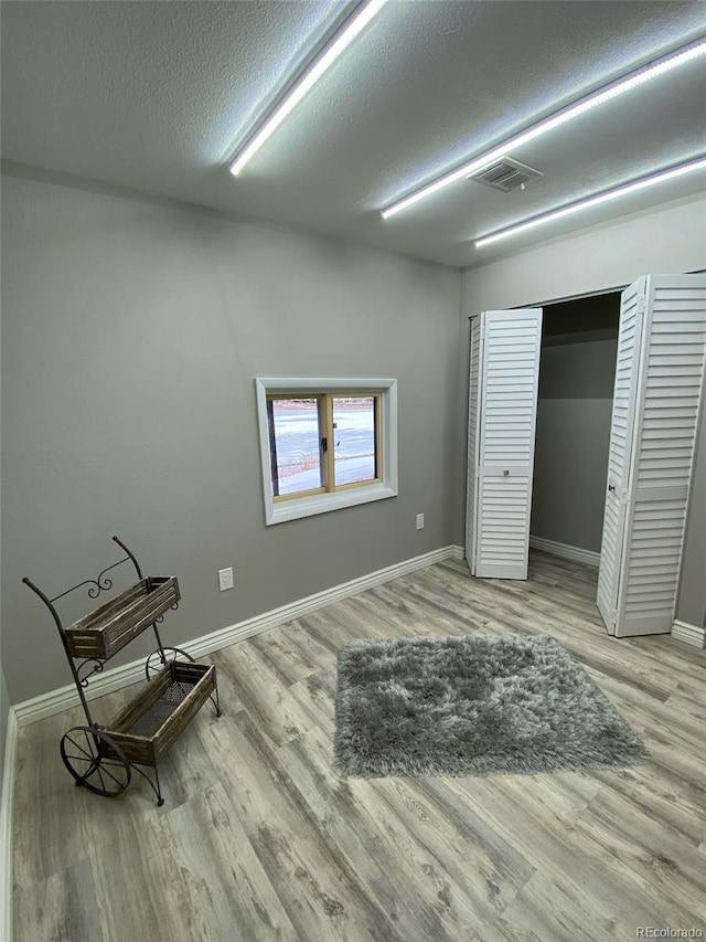 interior space featuring light hardwood / wood-style floors and a textured ceiling