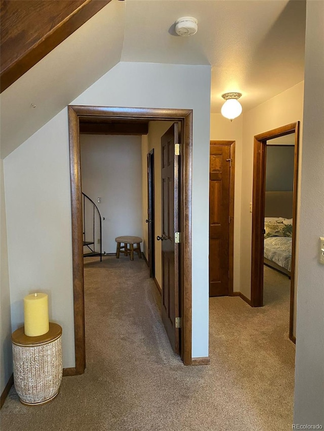 corridor featuring carpet flooring and vaulted ceiling