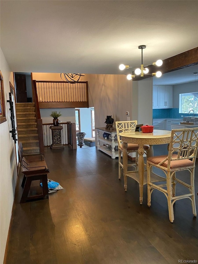 dining room featuring sink, dark hardwood / wood-style floors, and a chandelier