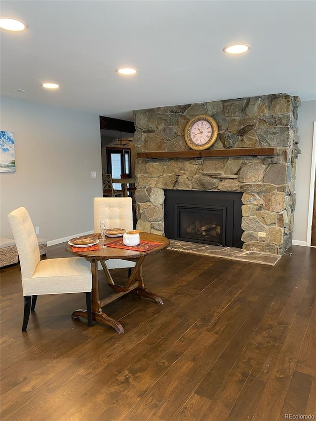 dining room with hardwood / wood-style flooring and a fireplace