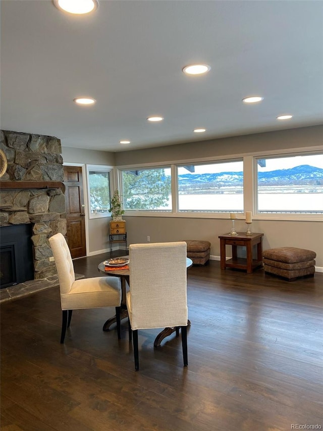 dining room with dark hardwood / wood-style flooring and a fireplace