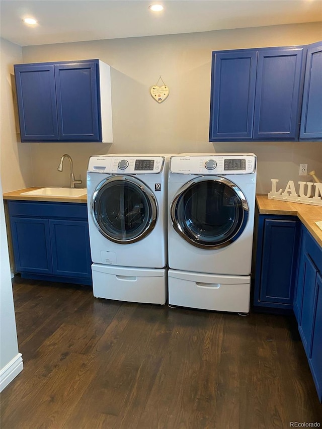 laundry area featuring dark wood-type flooring, cabinets, sink, and washing machine and dryer