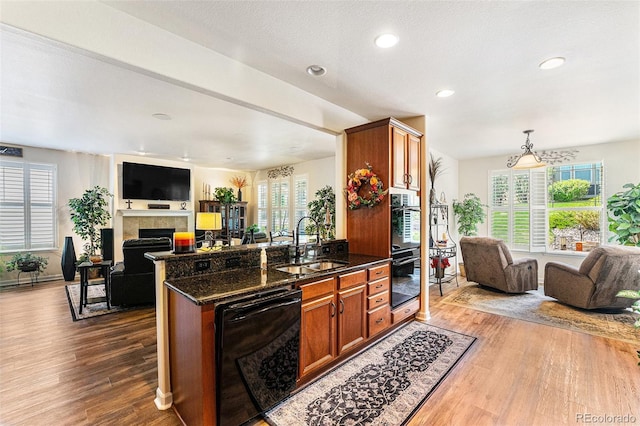 19780 W 57th Ln, Golden, CO 80403 - kitchen featuring black appliances, open floor plan, a sink, dark wood-type flooring, and a tile fireplace