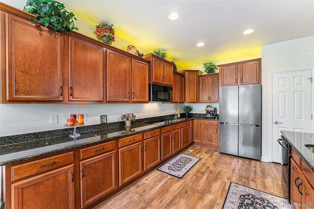 19780 W 57th Ln, Golden, CO 80403 - kitchen featuring black appliances, light wood-style floors, brown cabinets, recessed lighting, and dark stone countertops
