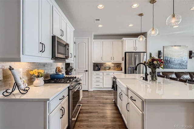 kitchen featuring light countertops, dark wood-style flooring, appliances with stainless steel finishes, and a sink