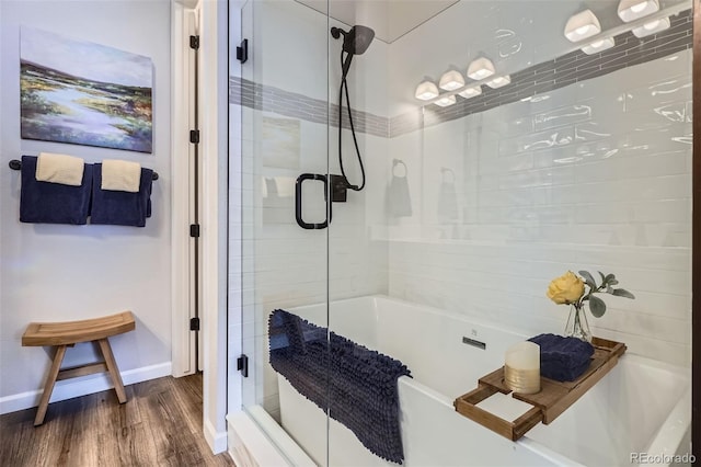 full bathroom with a tub to relax in, baseboards, a shower with door, and wood finished floors