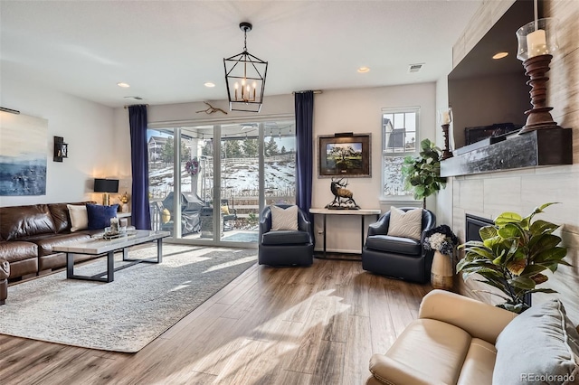 living area featuring visible vents, recessed lighting, wood finished floors, and a tiled fireplace