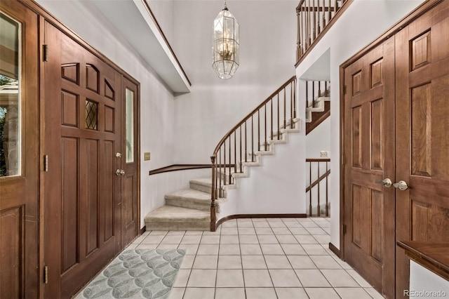 9420 Mcgill Ct, Parker, CO 80134 - entrance foyer with stairs, a chandelier, light tile patterned floors, and a high ceiling