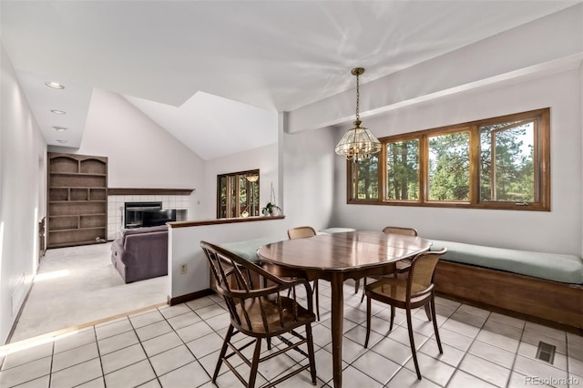 9420 Mcgill Ct, Parker, CO 80134 - dining room with light tile patterned floors, a tile fireplace, a chandelier, vaulted ceiling, and light carpet