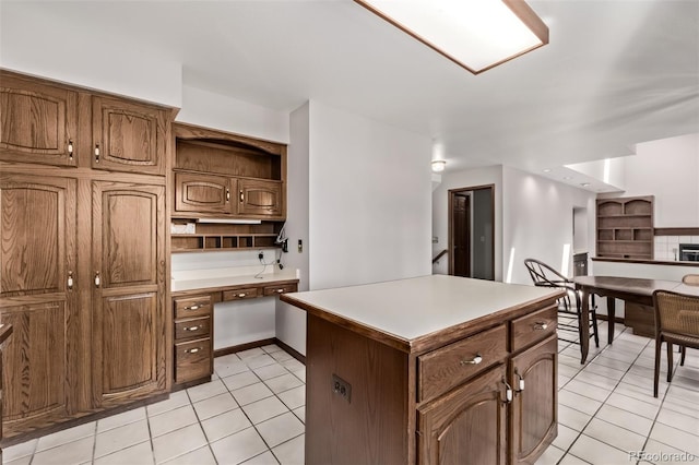 9420 Mcgill Ct, Parker, CO 80134 - kitchen featuring open shelves, light tile patterned flooring, a kitchen island, built in desk, and light countertops