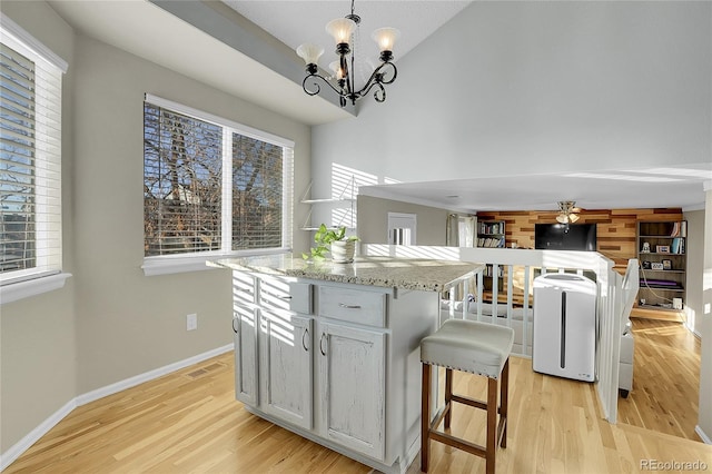 kitchen featuring a chandelier, light wood-type flooring, decorative light fixtures, and a wealth of natural light