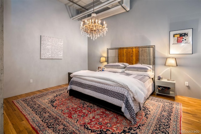 bedroom featuring a chandelier and wood-type flooring