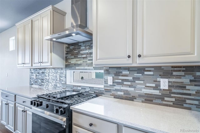 4947 N Quatar St, Aurora, CO 80019 - kitchen with wall chimney range hood, stainless steel range with gas cooktop, backsplash, and white cabinets