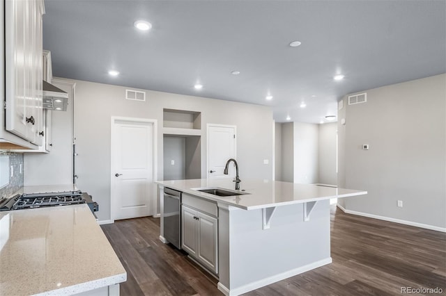 4947 N Quatar St, Aurora, CO 80019 - kitchen with a kitchen island with sink, dark wood-style floors, stainless steel dishwasher, recessed lighting, and white cabinetry