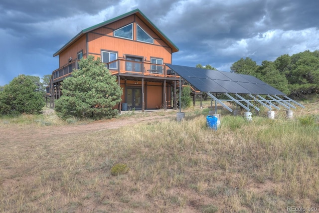 rear view of house featuring solar panels