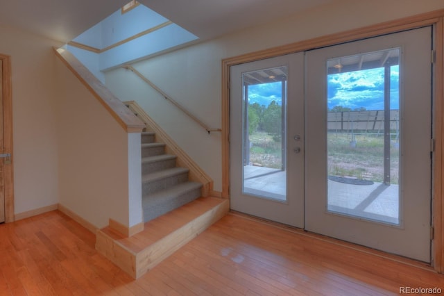 entryway with french doors, light hardwood / wood-style flooring, and a healthy amount of sunlight