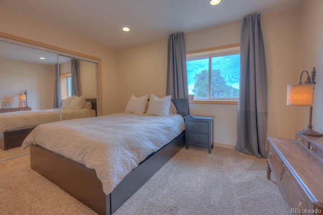 bedroom with light colored carpet and a closet