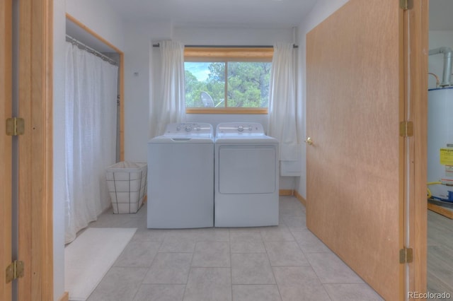 laundry room with light tile patterned flooring, gas water heater, and separate washer and dryer