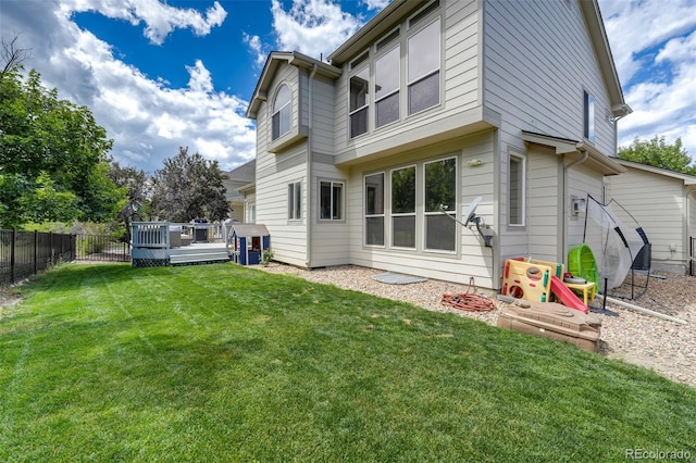 back of property featuring a yard and a wooden deck