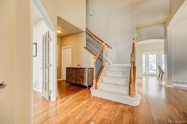 interior space with light hardwood / wood-style floors and a towering ceiling