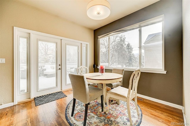 dining room with french doors and light hardwood / wood-style flooring