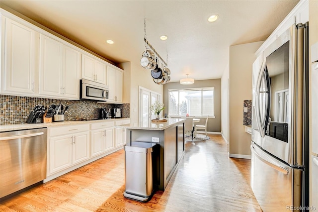 kitchen featuring a center island, light wood-type flooring, white cabinetry, and stainless steel appliances