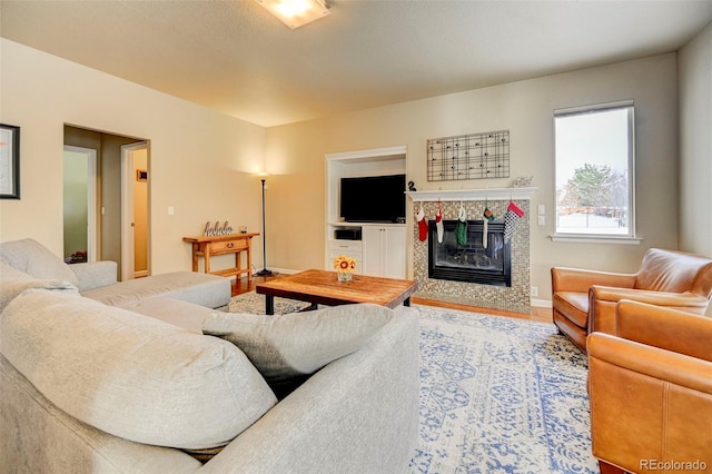 living room with hardwood / wood-style flooring and a tile fireplace