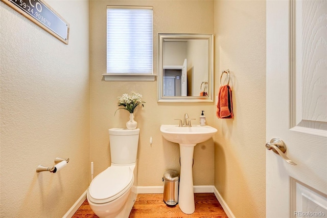 bathroom with hardwood / wood-style floors and toilet