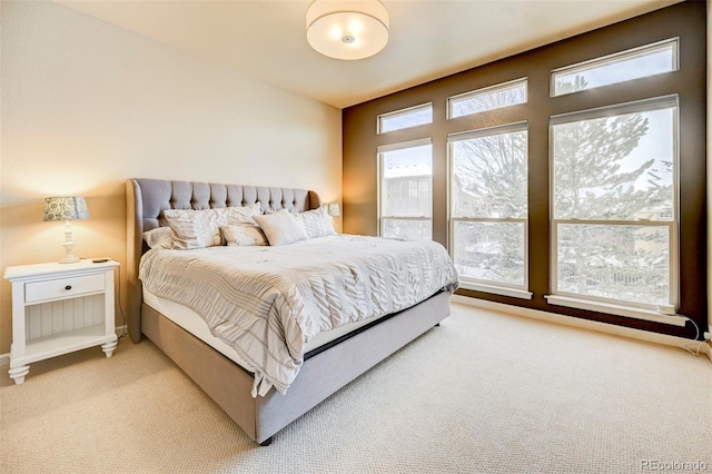 bedroom with light carpet and multiple windows