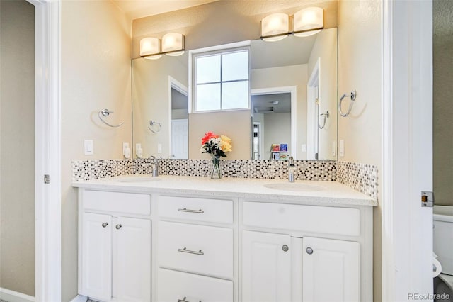 bathroom with vanity, toilet, and backsplash