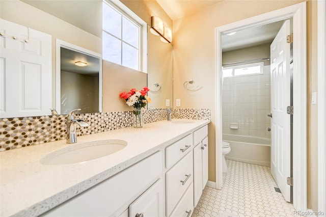 full bathroom with vanity, toilet, tiled shower / bath, and tasteful backsplash