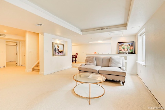 carpeted living room featuring a tray ceiling