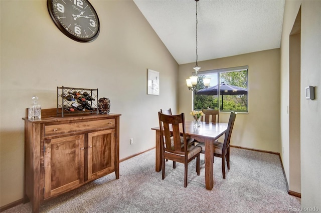 dining room featuring a chandelier, light colored carpet, baseboards, and lofted ceiling
