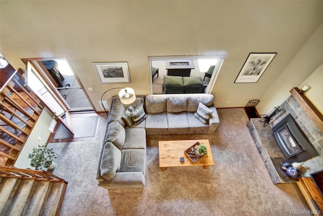 living area with carpet, a glass covered fireplace, and baseboards