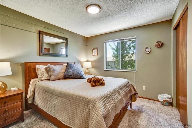 bedroom featuring carpet flooring, a closet, and a textured ceiling