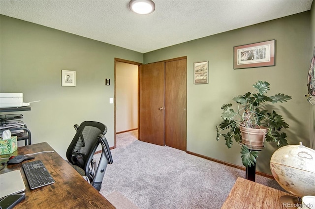 carpeted office with baseboards and a textured ceiling