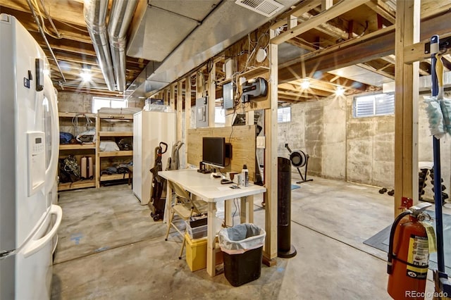 basement featuring white fridge with ice dispenser