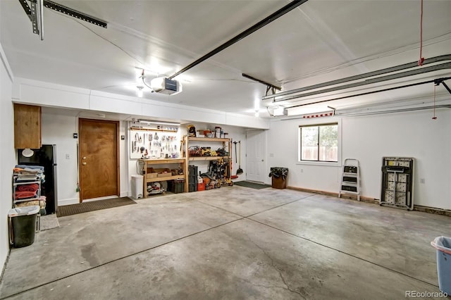 garage featuring a garage door opener and freestanding refrigerator