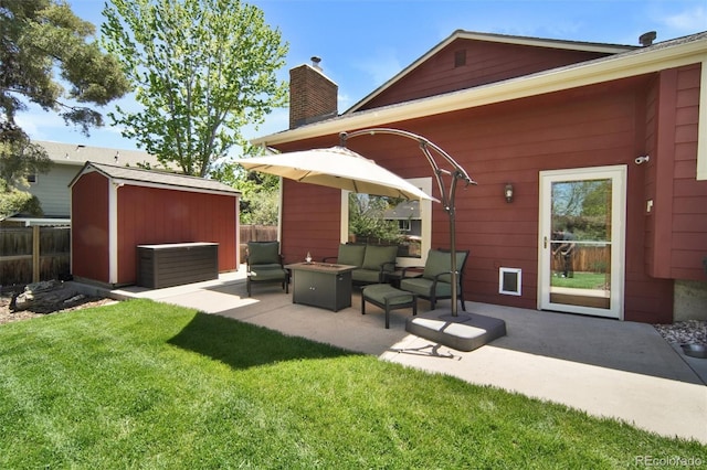 view of patio / terrace with a storage shed, an outbuilding, and an outdoor living space with a fire pit