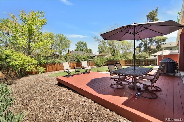 wooden deck featuring a fenced backyard, outdoor dining area, and grilling area
