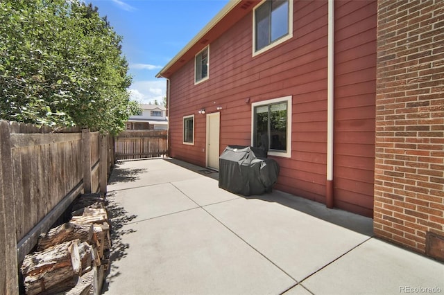 back of property featuring a patio area, fence, and brick siding
